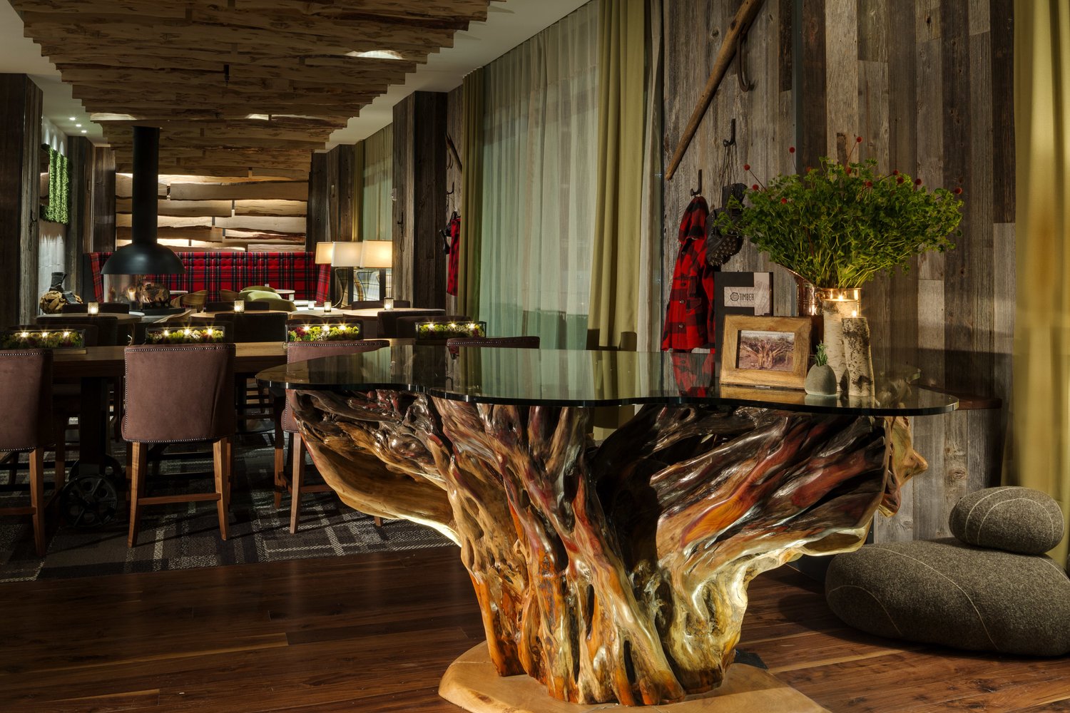 A lounge with a live-edge wood table and the bar glowing in the background.