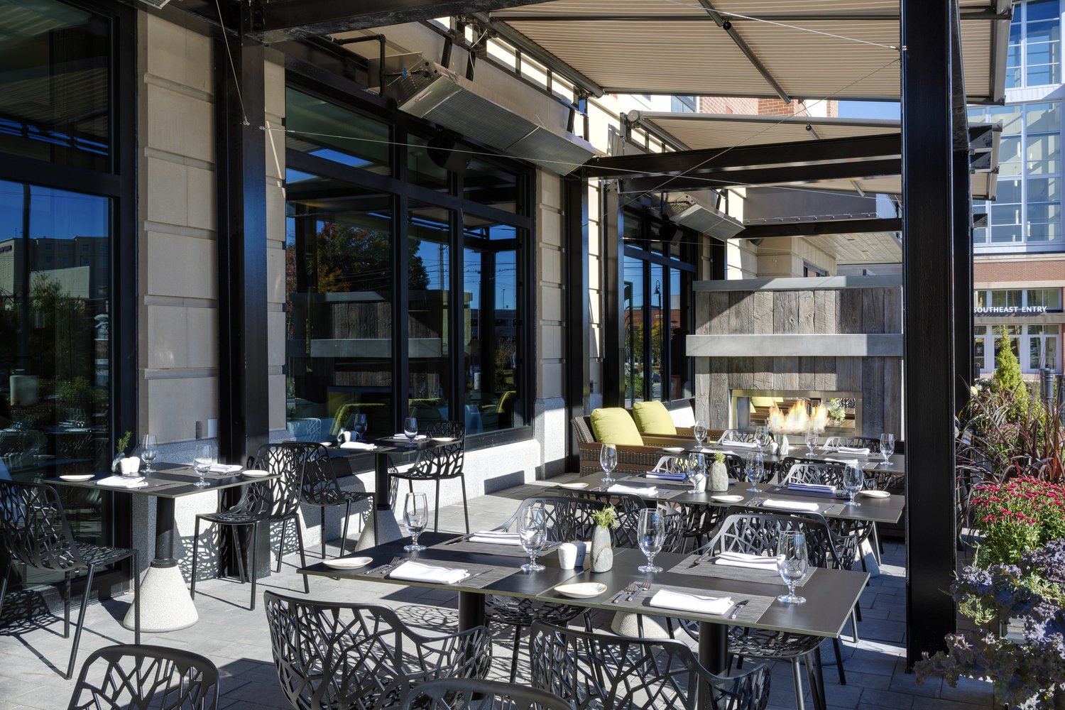 The covered outdoor patio with tables and a low garden wall.